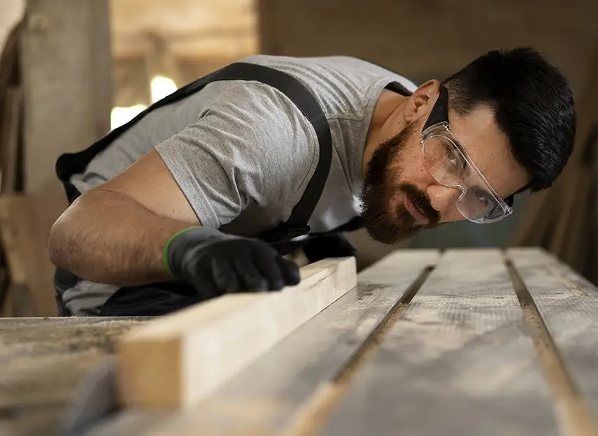 Carpintero inspeccionando una tabla de madera